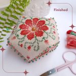 Biscornú Peonia bordado a mano. Completamente terminado. Pequeño cojín octogonal minuciosamente bordado a manoen punto de cruz con motivos florales en varios tonos de rosa y verde terminado con cuentas de cristal verde y centro dorado.